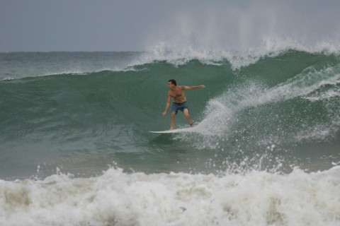 A surfer rides a wave at La Pared beach as Hurricane Erin approaches in Luquillo, Puerto Rico
