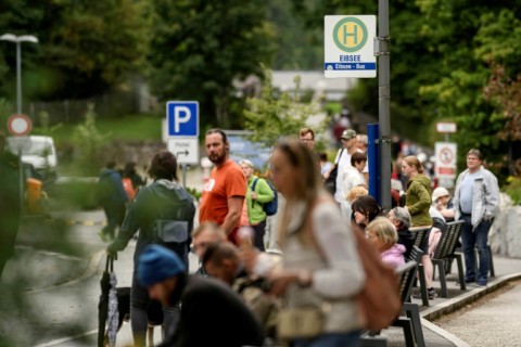 Tourists wait at a bus to get to the lake near Garmisch-Partenkirchen, southern Germany