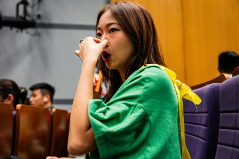 A participant pinches her nose to help her better perform a bird call at the Hong Kong Bird Watching Society's inaugural competition