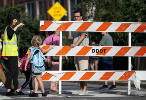 A staff member talks with a student on the first day of school in Washington