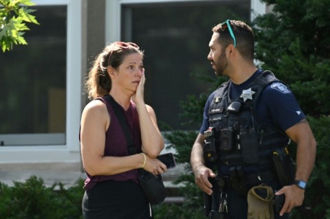A woman speaks to a police officer near the scene of the shooting