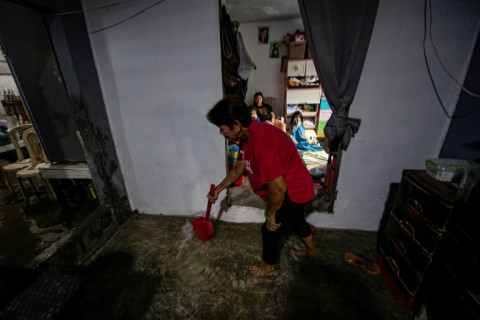 Maria Tamayo spends every morning scooping water from her flooded house on Isla Pugad north of Manila