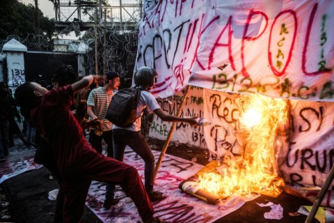 Demonstrators set banners alight as they shout slogans during at a protest in Bandung on Java island