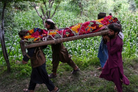 Afghan men carry the shrouded body of an earthquake victim for burial in Nurgal, Junar province