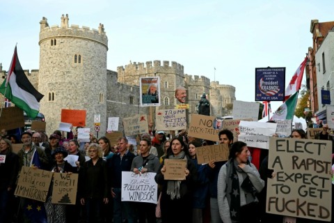 Demonstrators hold placards during a protest against the forthcoming State Visit of US President Donald Trump, outside Windsor Castle in Windsor