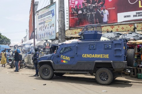 A gendarme stands guard next to an armoured vehicle in Conakry ahead of Guinea's constitutional referendum