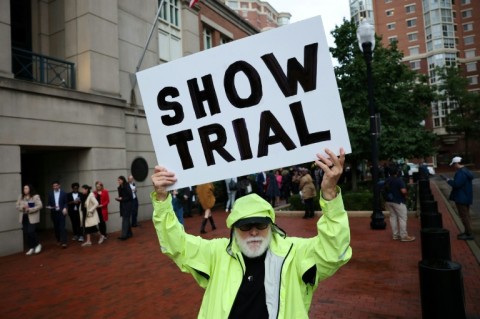 Bill Christeson holds up a sign that reads "Show Trial" outside the Virginia court where former FBI director James Comey is to be arraigned