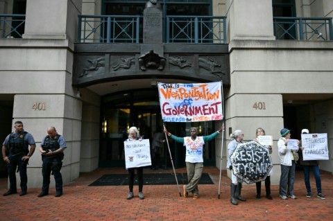 Demonstrators protest outside of the Albert V. Bryan United States Courthouse ahead of the arraignment of former FBI director James Comey