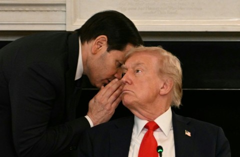 US Secretary of State Marco Rubio whispers in the ear of President Donald Trump