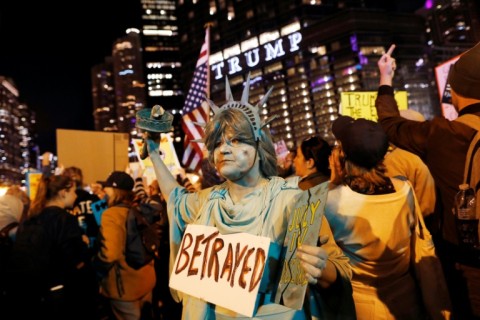 A protester in a Statue of Liberty costume protests the arrival of National Guard troops and US Immigration and Customs Enforcement agents in the Chicago area