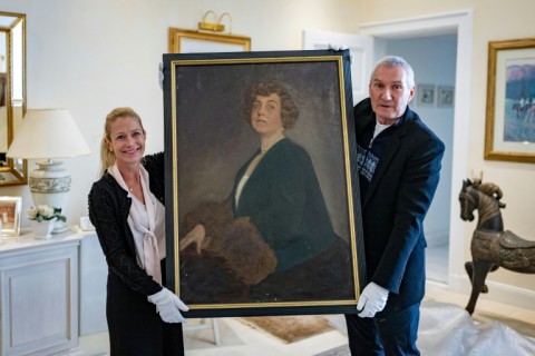 The long-lost oil painting of Madam Kitty Schmidt, shown by authors Urs Brunner and Julia Schrammel