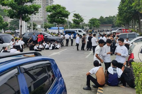 Employees at a shopping mall gather outside the building in Davao City, on the southern island of Mindanao after a 7.4-magnitude earthquake struck off the southern Philippines