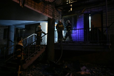 Ukrainian firefighters work in a residential building, damaged during the massive Russian drone and missile strikes