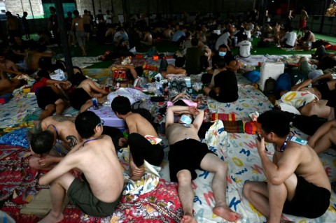 Released scam centre workers wait to be brought into Thailand during the crackdown in February