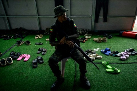 A Karen Border Guard Force (BGF) guard watches over scam centre workers during the crackdown