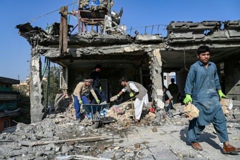 Workers remove debris from a house damaged after a a suspected air strike in Kabul