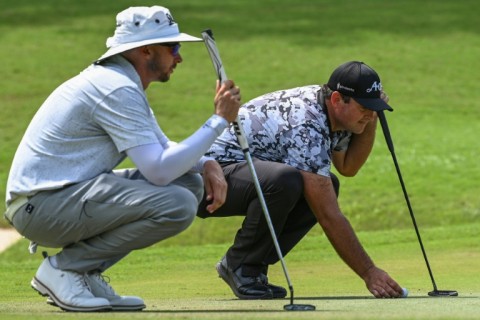 Patrick Reed (right) and fellow American John Catlin line up putts during the first round of the International Series Philippines on Thursday
