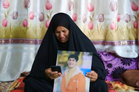 Zeinab Jabbar, 54, cries as she looks at a video of her missing son Mohammed