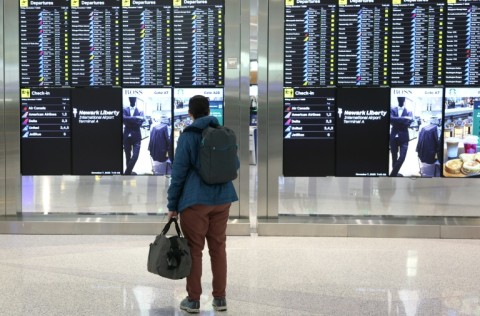 A man looks at the departures board at Newark Liberty International Airport