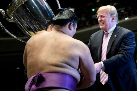US President Donald Trump presenting the President's Cup to sumo wrestler Asanoyama during the Summer Grand Sumo Tournament at Ryogoku Kokugikan Stadium in Tokyo
