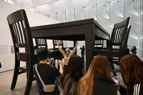 Visitors pose for photos with Robert Therrien’s large-scale artwork titled "Under the Table," during the exhibition "Robert Therrien: This is a Story" at The Broad in Los Angeles, California