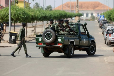 Soldiers patrol a street near the scene of gunfire near the presidential palace in Bissau on November 26, 2025
