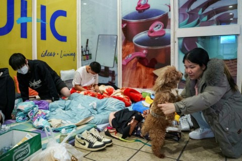 Displaced residents rest on donated mattresses inside a shopping mall near the scene of a major fire in Hong Kong