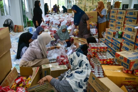 People prepare food aid packages for flood-affected residents in Thailand's southern province of Narathiwat