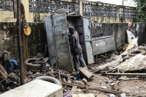 A young mechanic looks for spare parts at the back of Mamadou Diallo Yero's garage in Conakry