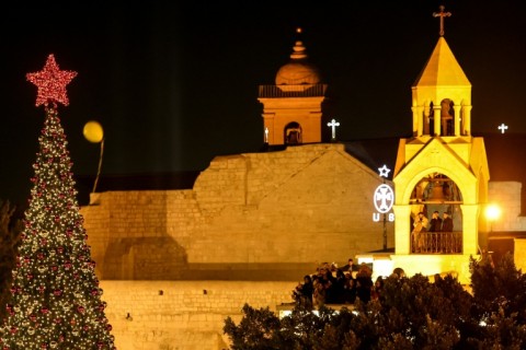 Covered in red and gold baubles, the Christmas tree standing metres away from the Church of the Nativity on Manger Square has become a symbol of hope