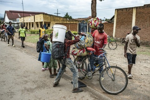 Lines of civilians crossed the border, watched by Rwandan police