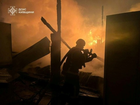 A Ukrainian firefighter extinguishes a fire at a site of an air attack in the Kyiv region