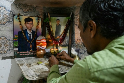 Suresh Patni prays near portraits of his 12-year-old son who was killed in the Air India crash