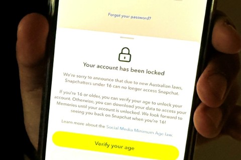 A 13-year-old boy displays a message on his mobile phone from social media platform Snapchat after his account was locked for age verification in Sydney