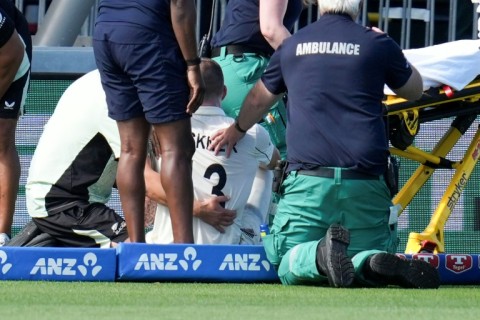 New Zealand's Blair Tickner is treated after being hurt fielding