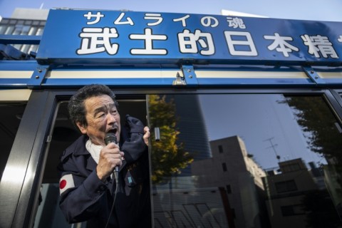 A member of the ultra-nationalist group on Taikosha's 'Samurai Spirit' bus shouts towards the Russian Embassy during a rally in Tokyo
