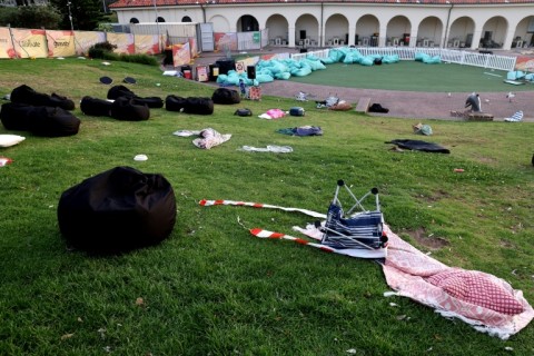 A grassy hill overlooking Bondi Beach is strewn with discarded items from people fleeing the killing