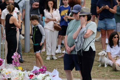 Mourners gather around floral tributes at Bondi Pavilion to honor the victims of the Bondi Beach shooting on December 16, 2025.