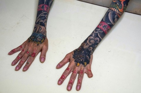 Retired yakuza Mako Nishimura shows her dragon and tiger tattoos and a finger cut off in a ritualistic self-punishment for blunders