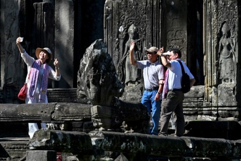 Tourists taking selfies as they visit the Bayon temple in Siem Reap province