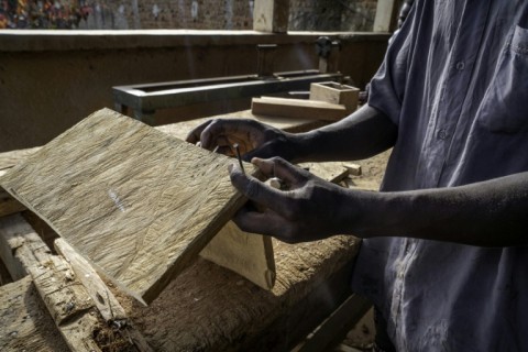 A man works as a carpenter in a workshop dedicated to training former child soldiers in the Democratic Republic of Congo