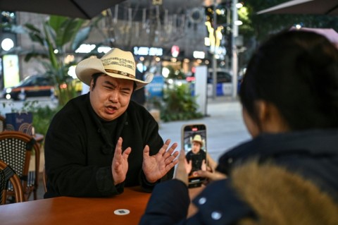 Donald Trump impersonator Ryan Chen speaks as his assistant records him in southwestern China's Chongqing municipality