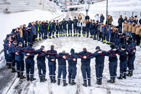 Firefighters and emergency responders stood in a circle in Crans-Montana