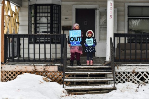 Children hold signs along the route of the protest march in Minneapolis