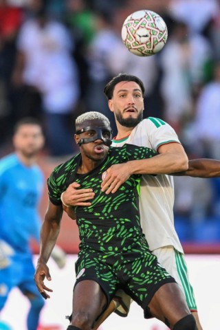 Osimhen holds off Ramy Bensebaini during Nigeria's quarter-final win over Algeria in Marrakesh