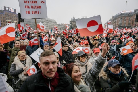 Protesters wave Greenlandic flags as they take part in a rally at city hall in Copenhagen