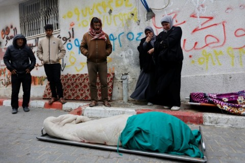 Palestinians mourn over a body