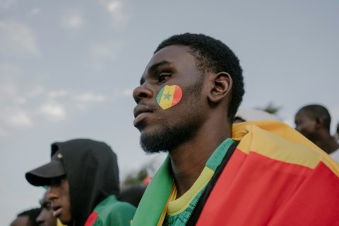 A Senegal football fan watches the AFCON final at a 'fan zone' at the African Renaissance Monument in Dakar