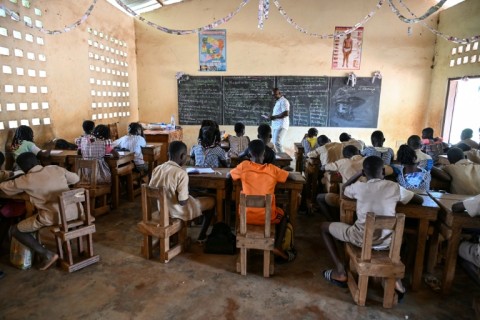 Children of cocoa producers studying in a classroom without electricity