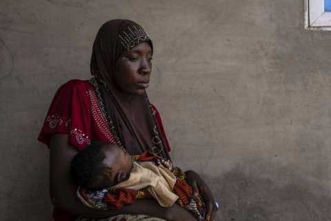 Khausara Saleem, 28, holds her three-month-old baby after fleeing the massacre in the Nigerian village of Woro